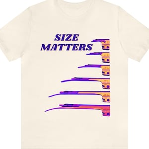 Könnte beinhalten: Ein weißes T-Shirt mit dem Text "SIZE MATTERS" in lila auf der Vorderseite. Der Text wird von einer Grafik einer Reihe von chirurgischen Instrumenten in einem Farbverlauf von Orange und Lila begleitet.