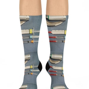 May include: A pair of blue and gray socks with a pattern of medical instruments, including syringes and laryngoscopes.