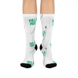 May include: White socks with a green and purple pattern of IV bags and the text "PULL & PRAY" repeated throughout.