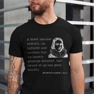 Könnte beinhalten: Schwarzes T-Shirt mit Rundhalsausschnitt, weißem Text und einem Porträt. Der Text lautet: „Ein sehr bemerkenswerter Feigling, ein unendlicher und endloser Lügner, ein stündlicher Versprechensbruch, der Besitzer keiner guten Qualität.“ Text von Shakespeare.