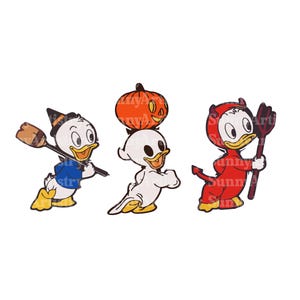 Könnte beinhalten: Drei Cartoon-Enten, die sich für Halloween verkleidet haben. Eine ist eine Hexe mit einem Besen, eine andere ist ein Geist mit einem Kürbis und die dritte ist ein Teufel mit einer Heugabel.