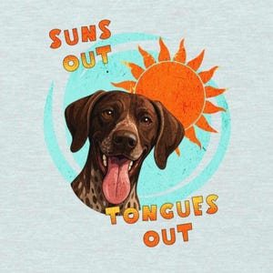 Può includere: T-shirt azzurra con una grafica di un cane marrone con la lingua di fuori, un sole arancione brillante e la scritta "Suns Out Tongues Out" in arancione. Il cane è all'interno di un cerchio azzurro.