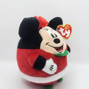 Puede incluir: Juguete de peluche rojo y negro de Minnie Mouse con un traje de Pap&aacute; Noel rojo y blanco con cuello verde. El juguete tiene una etiqueta Ty Beanie Ballz unida a su oreja.