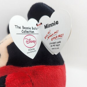 Puede incluir: Un juguete de peluche rojo y negro con forma de Minnie Mouse. El juguete forma parte de la colecci&oacute;n Disney Beanie Ballz. La etiqueta dice "&iexcl;R&oacute;deme! &iexcl;L&aacute;nzame! &iexcl;Atr&aacute;pame! Siempre aterrizo de pie."