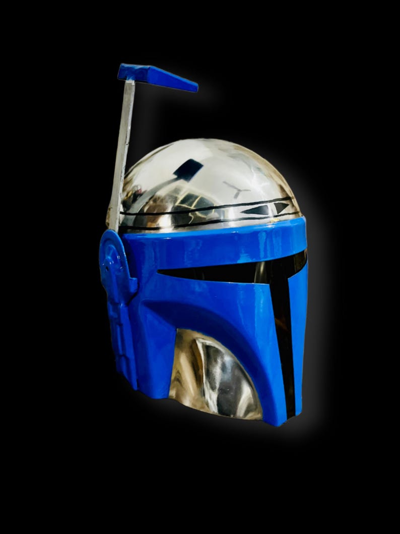 May include: A blue and silver Mandalorian helmet with a raised antenna. The helmet has a black visor and a blue faceplate.