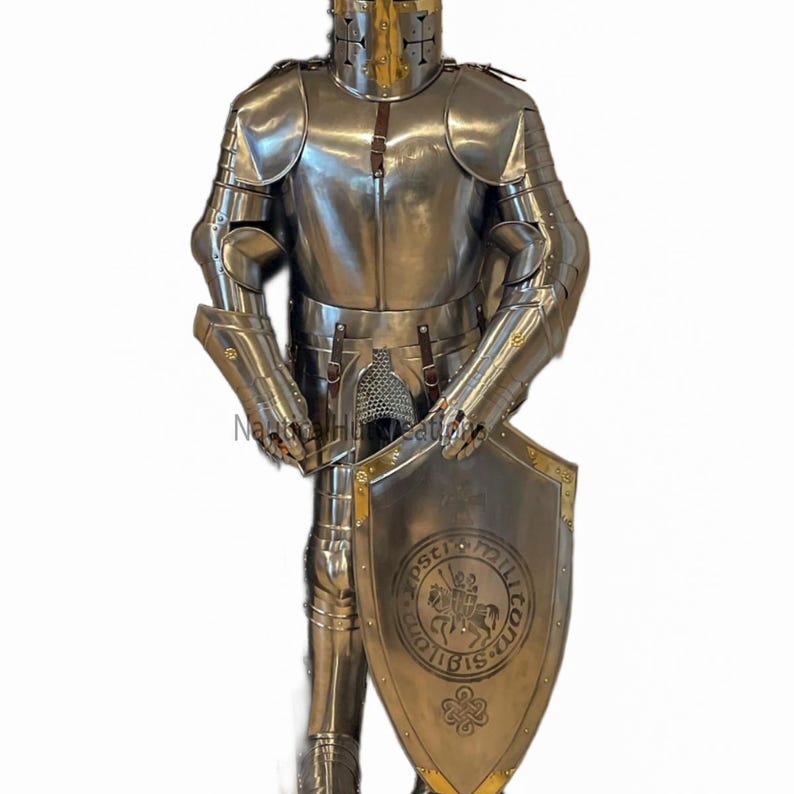 Puede incluir: Una armadura completa de plata y dorada con un escudo que presenta un caballero a caballo y el texto "OPSC" y "MILITIA" en un c&iacute;rculo. El escudo tambi&eacute;n tiene un dise&ntilde;o de nudo celta en la parte inferior.