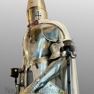 Puede incluir: Un caballero de plata con armadura completa, una capa blanca y un escudo con una cruz negra. El caballero sostiene una espada y una antorcha.