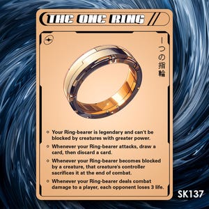 May include: A gold ring with a textured surface and the text "THE ONE RING" and "一つの指輪" on a card with a white background.