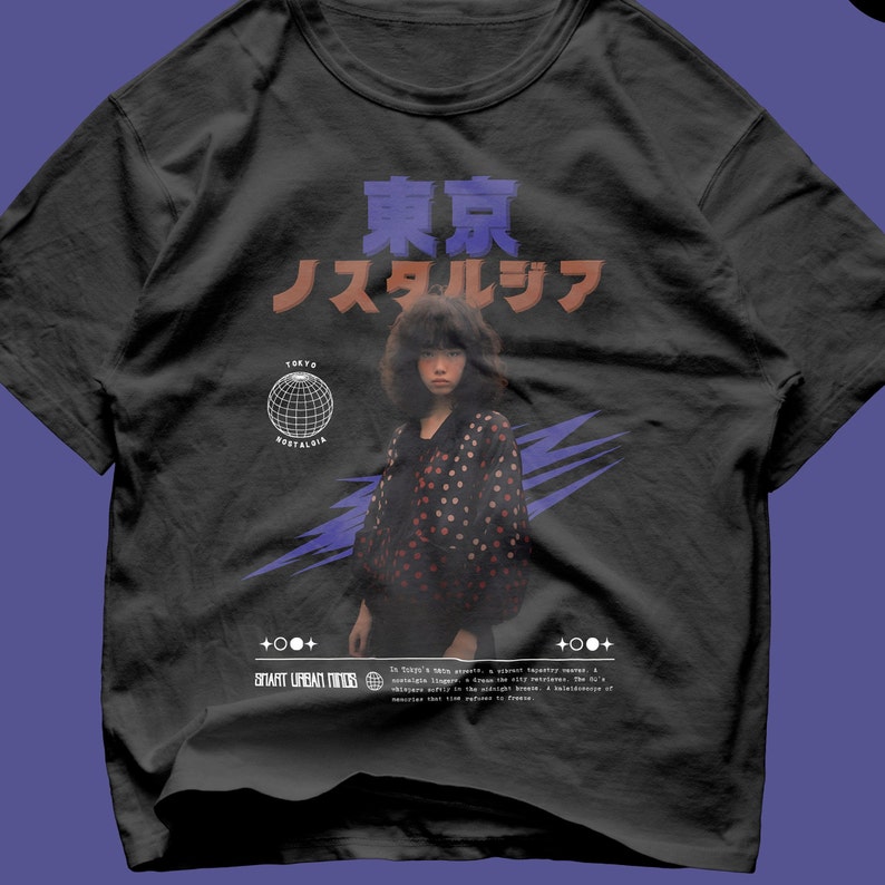 May include: A black crew neck t-shirt featuring a graphic print of a person with dark hair wearing a polka dot shirt. The design includes Japanese text, a wireframe globe, purple lightning bolts, and the text "TOKYO NOSTALGIA" and "SMART URBAN MINDS".