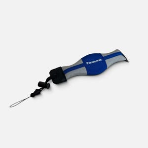 May include: A blue and grey camera wrist strap featuring the Panasonic logo in white text. The strap includes a black plastic connector and a thin black cord loop for attachment, designed with a contoured shape for comfort and secure handling.