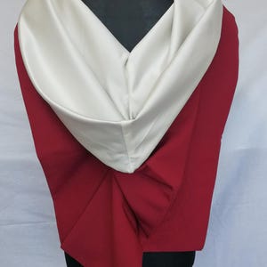 May include: A red and white hooded garment with a satin collar. The hood is folded down and the garment is draped over a mannequin.