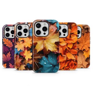 May include: A collection of five phone cases featuring vibrant autumn leaf designs. The cases showcase a variety of colorful leaves, including shades of red, orange, yellow, and blue, with water droplets visible on some leaves.