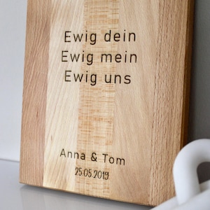 May include: A wooden cutting board with the text "Ewig dein Ewig mein Ewig uns" and "Anna & Tom 25.05.2019" engraved on it.