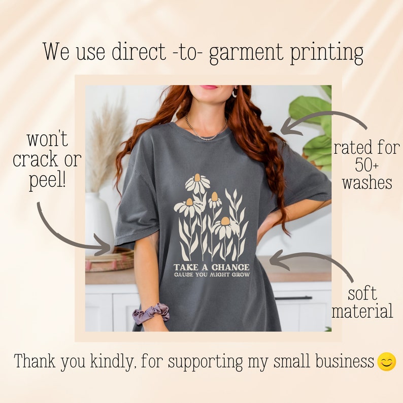 May include: A dark gray t-shirt with a floral design and the text "Take a chance cause you might grow".