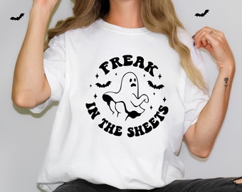 May include: White t-shirt with a black graphic of a ghost with the text "Freak in the Sheets".