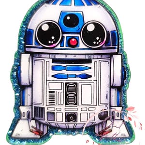 May include: A cartoon illustration of R2-D2, a robot from the Star Wars franchise. The robot is white with blue accents and has large, round eyes. The image is surrounded by a green glitter border.