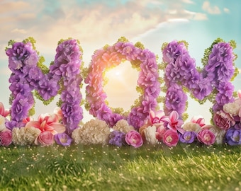 May include: The word "MOM" spelled out with purple flowers against a blue sky background. The flowers are arranged in a circle shape, creating a wreath-like effect. The flowers are surrounded by a field of green grass.