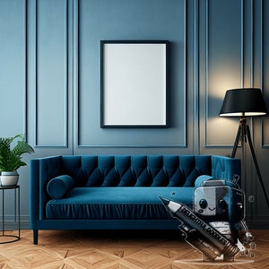 May include: A blue velvet sofa with a pillow in a blue room with a black framed picture and a black floor lamp with a black lampshade.