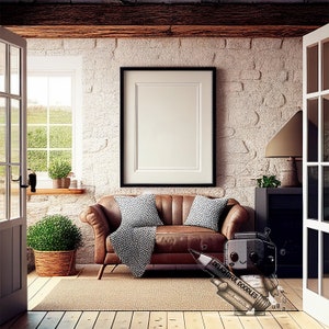 Könnte beinhalten: Ein braunes Ledersofa mit zwei Kissen und einer Wolldecke in einem Wohnzimmer mit einer Backsteinwand, einem großen gerahmten Bild, einer Topfpflanze und einer Lampe. Das Sofa steht vor einem großen Fenster mit Blick auf einen grünen Rasen.