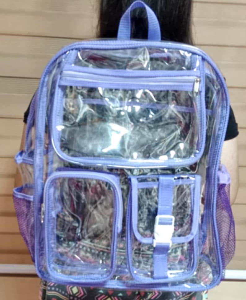 Op de afbeelding: Een transparante rugzak van plastic met paarse afwerking en meerdere vakken. De rugzak heeft een mesh-vak aan de zijkant en een ritsvak aan de voorkant.
