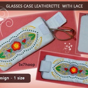 May include: White glasses case with a floral embroidery design in red, yellow, and green. The case is made of leatherette and has a lace trim. The text "5x7hoop" is printed on the case. The text "1 design - 1 size" is printed below the case.