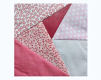May include: A patchwork of fabric squares in shades of pink and white. The squares feature different patterns, including hearts, leaves, and polka dots.