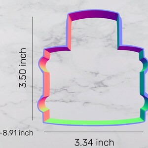 May include: A colorful plastic cookie cutter shaped like a three-tiered cake. The cutter is 3.50 inches tall and 3.34 inches wide.