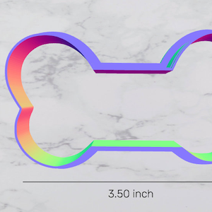 May include: A rainbow-colored plastic dog bone cookie cutter with a 3.50 inch length and 1.91 inch height. The area of the cutter is 4.85 square inches.