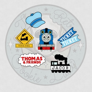 May include: A collection of cartoon train-themed illustrations. Includes a blue train, a conductor's hat, train tickets, a train crossing sign, and the text "THOMAS & FRIENDS". Also features a black train with the name "JACOB".