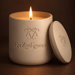 Può includere: Una candela beige accesa in un contenitore cilindrico con coperchio abbinato. La candela ha una fiamma e il contenitore è impresso con il testo "KerzenKenner" e un logo decorativo. Il coperchio è appoggiato accanto al contenitore.