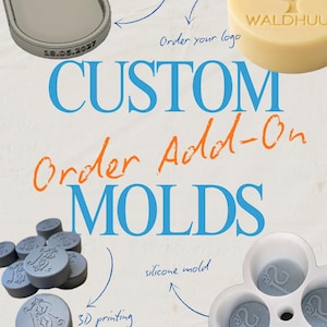May include: A collection of custom silicone molds featuring an oval tray with the text AMOUR and 18.06.2027, a round mold with a tree design and the text WALDHUU, and several small circular gray wax seals with embossed monograms.