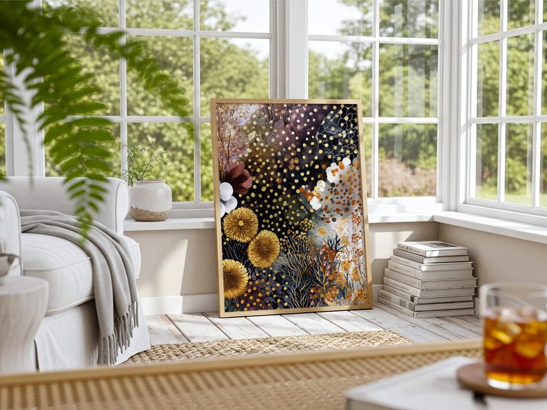 Puede incluir: Una impresi&oacute;n art&iacute;stica floral enmarcada con un dise&ntilde;o abstracto. La obra de arte presenta flores amarillas, blancas y burdeos sobre un fondo oscuro con detalles dorados. La impresi&oacute;n se exhibe en una habitaci&oacute;n luminosa y soleada.