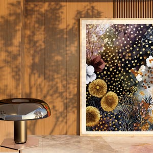 Puede incluir: Una pintura de acuarela enmarcada con un tema floral. La obra de arte presenta un fondo oscuro con puntos dorados y varias flores en tonos de amarillo, blanco y burdeos. La pintura se exhibe sobre una superficie de m&aacute;rmol.