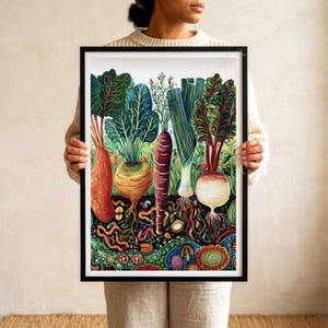 May include: A framed art print featuring a colorful illustration of various root vegetables including carrots, beets, and leeks growing in soil. The artwork depicts the plants above ground with green foliage and the root systems below with earthworms.