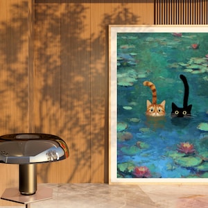 May include: A framed print shows two cats in a pond with lily pads and flowers. One cat is ginger and white, the other is black. The cats are in the water, with only their heads and tails visible. The artwork has a painterly style.