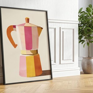 Pode incluir: Uma impressão artística emoldurada com uma ilustração colorida de uma cafeteira italiana. A obra de arte apresenta um design geométrico com listras rosa, laranja e amarelas. A impressão está encostada em uma parede branca ao lado de uma planta em vaso.