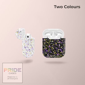 May include: Two Airpod cases with a black and white splatter paint design. The case on the left has a white background with black and purple splatter paint. The case on the right has a black background with white and purple splatter paint. The text "Two Colours" is at the top of the image. The text "PRIDE CASES" is at the bottom of the image. The text "Happiness is for Everyone" is below the text "PRIDE CASES".