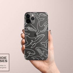 Peut inclure: Une coque de téléphone transparente avec un motif de baleines en contour blanc. La coque est noire et comporte une découpe pour l'appareil photo.