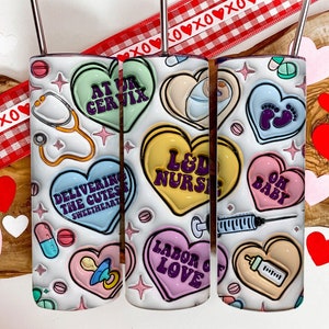 May include: Three white tumblers with a Valentine's Day theme. Each tumbler features a different design with candy hearts and text that says "At Ur Cervix", "L&D Nurse", and "Oh Baby".