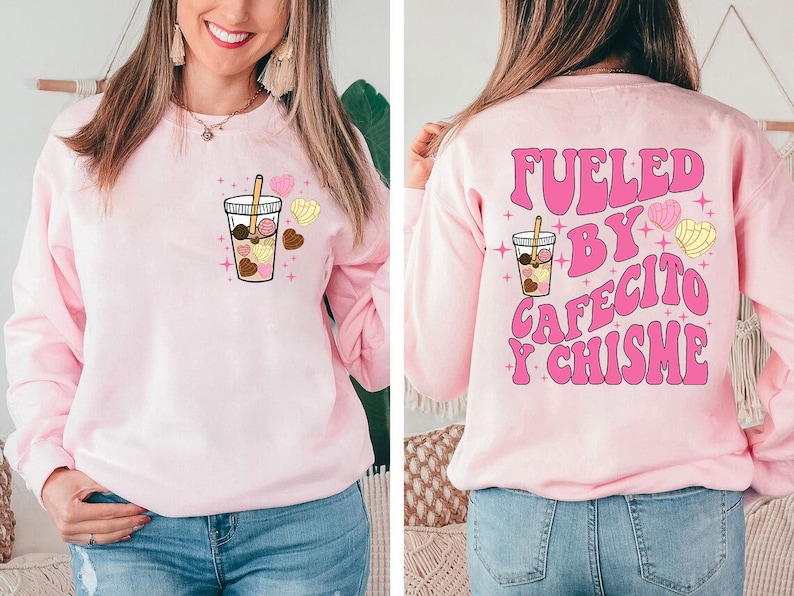 May include: Pink sweatshirt with a graphic of a coffee cup with pastries and the text "Fueled by Cafecito y Chisme" in pink letters.