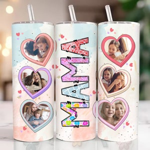 Op de afbeelding: Drie roestvrijstalen bekers met roze, blauwe en witte ontwerpen. Elke beker heeft een hartvormig frame met een foto van een moeder en een kind. De middelste beker heeft het woord "MAMA" in roze glitterletters geschreven.