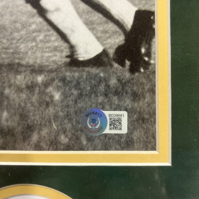 May include: A black and white photo of a person playing baseball. The photo is framed and has a Beckett Authentication sticker with the number BD38681.