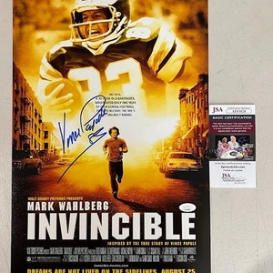 May include: A movie poster for the film "Invincible" starring Mark Wahlberg. The poster features a yellow and orange color scheme with a photo of Mark Wahlberg in a football uniform. The text "Invincible" is in large, bold letters and the tagline "Dreams are not lived on the sidelines" is below it. The poster also includes the release date of August 25.