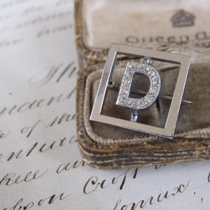 Lindo broche com letra D cromado Art Déco dos anos 1920 e cristais de pasta