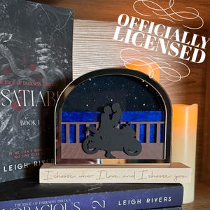May include: A black and white silhouette of a couple riding a motorcycle under a starry night sky. The scene is framed in a mirrored arch and set on a wooden base with the text "I choose who I love, and I choose you."