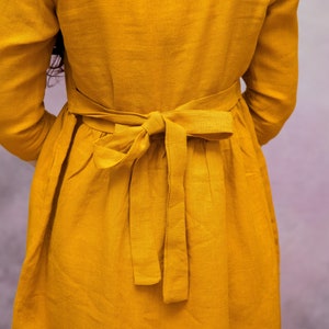 May include: A yellow linen dress with a self-tie sash in the back.