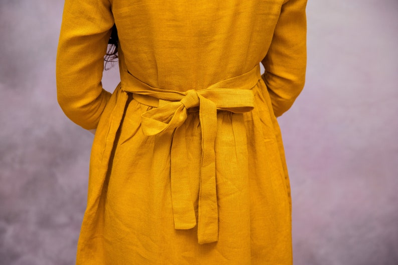 May include: A yellow linen dress with a self-tie sash in the back.