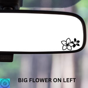 Pu&ograve; includere: Uno specchietto retrovisore per auto con cornice nera e superficie riflettente bianca. Due decalcomanie di fiori neri sono nell'angolo in basso a destra. Il testo "BIG FLOWER ON LEFT" &egrave; in basso.