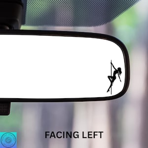 May include: A black silhouette of a pole dancer on a pole is affixed to a car's rearview mirror. The text "FACING LEFT" is below the mirror. The image is set against a blurred background.