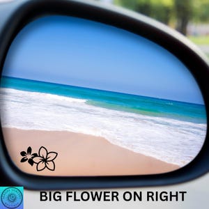 Pu&ograve; includere: Specchietto retrovisore per auto con una scena di spiaggia riflessa all'interno. Lo specchietto ha un contorno nero e una grafica floreale nera in basso a sinistra. Il testo "BIG FLOWER ON RIGHT" &egrave; in basso.